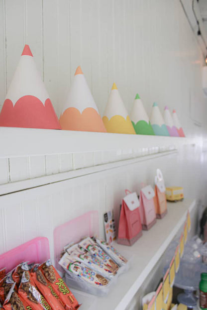 Colorful party hats on a shelf with snacks below