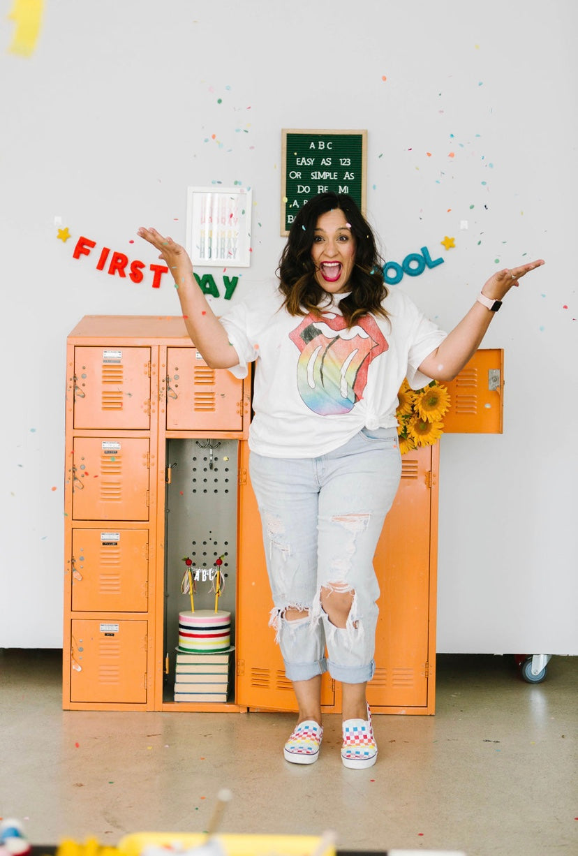Person in a classroom setting with orange lockers and educational decorations.