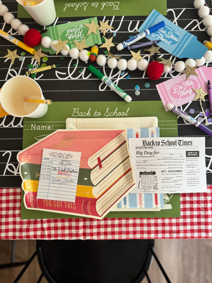 Back to school-themed table with stationery items on a checkered tablecloth.