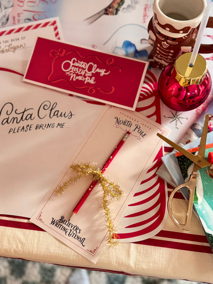 Letter to Santa Claus with a red envelope on a festive table setting.